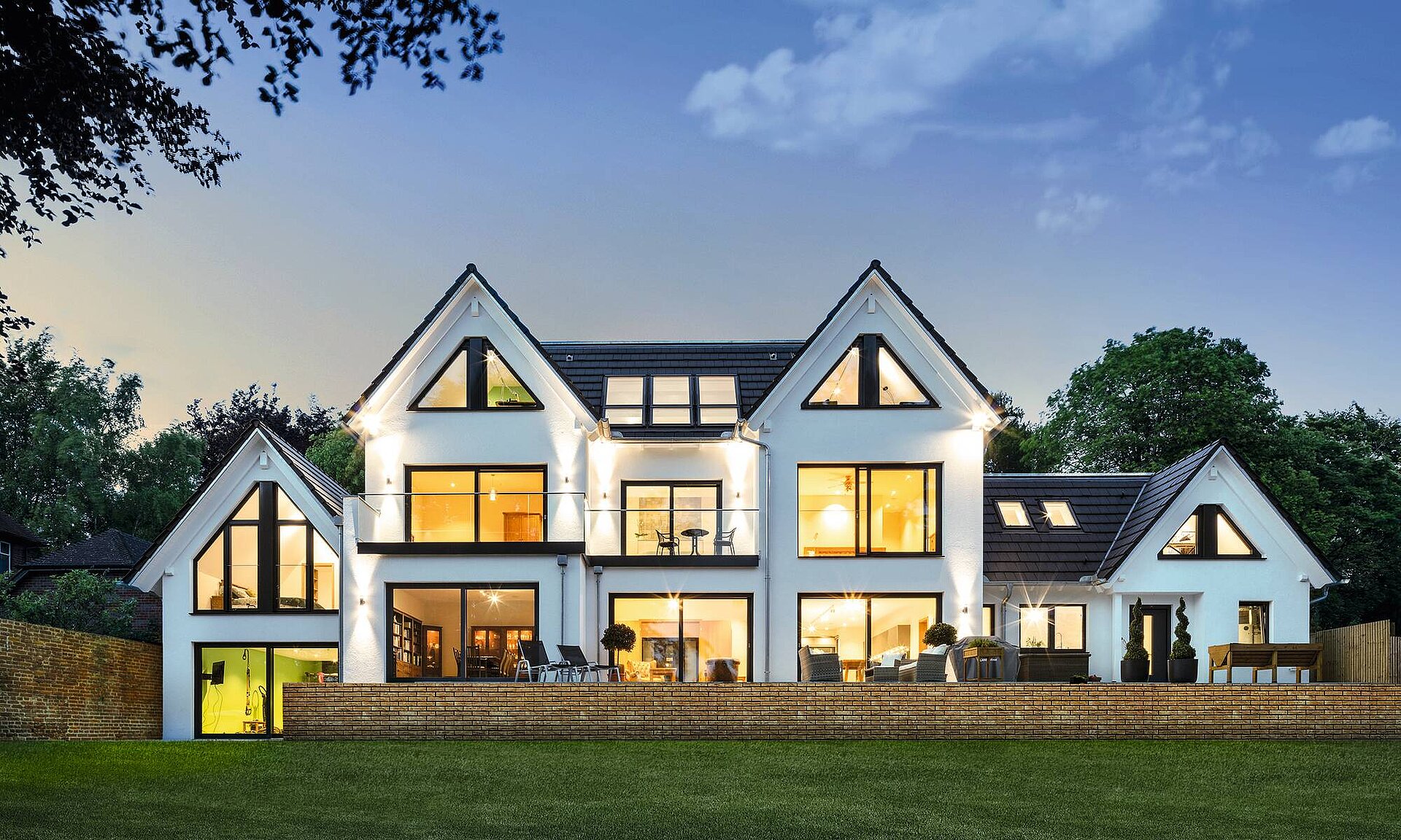 Haus mit großer Fensterfront in Abendstimmung Haus mit großer Fensterfront in Abendstimmung